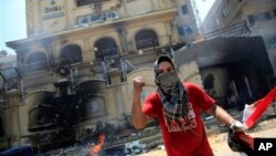 1일 무슬림형제단 본사 건물을 공격한 이집트 반정부 시위대 일원이 이집트 국기를 손에 쥐고 있다.