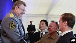 North Korean leader Kim Jong Il shakes hands with chief conductor of the main orchestra of the Defense Ministry, Viktor Yeliseyev, left, as Russian President Dmitry Medvedev smiles in Siberia's Buryatia region, August 24, 2011
