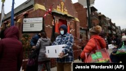 Warga yang membutuhkan menerima pembagian makanan gratis di Queens, New York selama pandemi (foto: ilustrasi). 