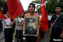 People hold General Aung San's portrait as they wait to pay respect during an event marking the anniversary of Martyrs' Day outside the Ministers' Building, formerly known as the Secretariat building, in Yangon, Myanmar, July 19, 2015.