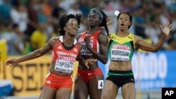 FILE: Trinidad and Tobago's Kelly-Ann Baptiste , left, collides with United States' Tori Bowie, center, and Jamaica's Natasha Morrison, right, after their women's 100m semifinal at the World Athletics Championships at the Bird's Nest stadium in Beijing, Monday, Aug. 24, 2015.