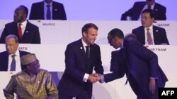 Le président français Emmanuel Macron serre la main du président rwandais Paul Kagame à côté du président tchadien Idriss Deby lors du 17e sommet des pays francophones à Erevan, le 11 octobre 2018.