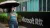 资料照片：一位女士走过微软公司在北京的办公楼。 (2021年7月20日)