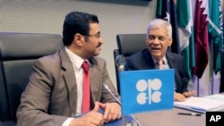 Qatari Mohammed Bin Saleh Al-Sada, President of the OPEC Conference, and OPEC's Secretary General Abdalla Salem El-Badri, from Libya, from left, share a word prior to the start of an OPEC meeting in Vienna, Austria, June 5, 2015.
