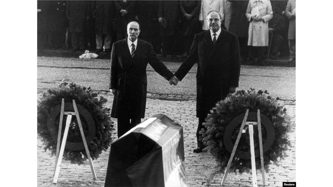 FILE - Helmut Kohl (R) stands hand in hand with former French President Francois Mitterrand (L), Sept. 22, 1984, during their visit to the former Verdun battlefields.