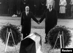 FILE - Helmut Kohl (R) stands hand in hand with former French President Francois Mitterrand (L), Sept. 22, 1984, during their visit to the former Verdun battlefields.