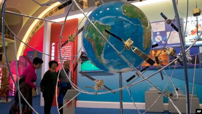 中國民眾參觀一個展示中國衛星技術的展覽（2017年10月19日）。中國蓬勃發展的太空計劃需要先進的衛星技術，以獲得與美國比肩的超級大國地位。但美國的法律禁止出口衛星技術。