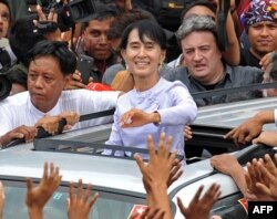 Aung San Suu Kyi (au c.) salue la foule après un discours à Rangoon (2 avril 2012)