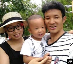 In this photo taken in 2016 and released by Deng Guilian, Deng Guilian, left, her husband Hua Haifeng, right, and their son Bo Bo pose for a photo during a visit to a park in Chengde in northern China's Hebei Province.