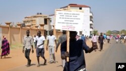 A demonstrator holds a placard during a rally protesting the United States' unilateral arms embargo on the country, in Juba, South Sudan, Feb. 6, 2018. 