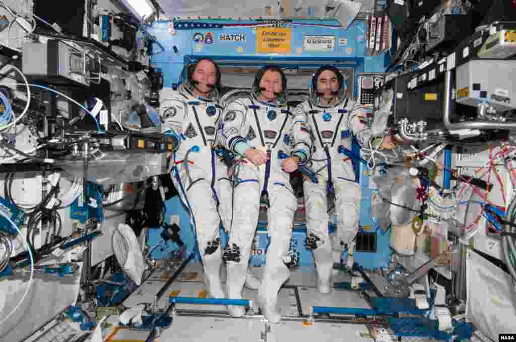 With their scheduled stay onboard the International Space Station headed toward its final days, three members of the Expedition 34 crew pose for some photographs in their Sokol suits in Destiny, the U.S. Laboratory . From left are NASA astronaut Kevin Ford, commander, with Roscosmos Flight Engineers Oleg Novitskiy and Evgeny Tarelkin.