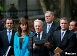 Former Colombian President Alvaro Uribe, center, accompanied by members of the Democratic Center party, speaks after a meeting with Colombian President Juan Manuel Santos at Narino Palace in Bogota, Colombia, Oct. 5, 2016.
