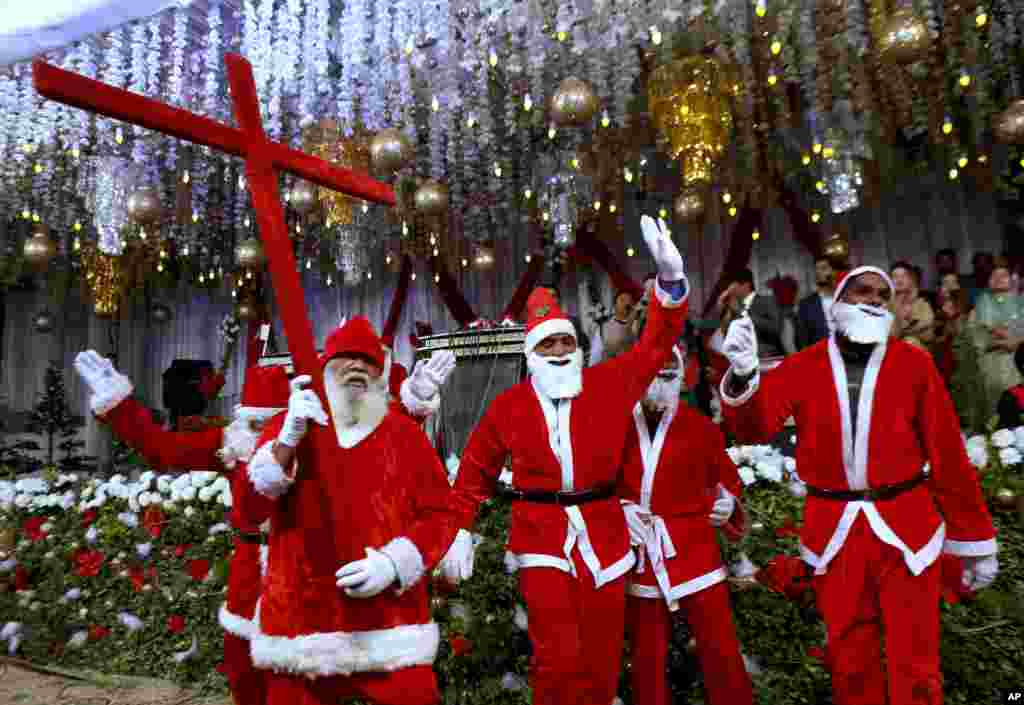 Pakistani Christians wear Santa Claus suits during a celebrations for Christmas, in Lahore.