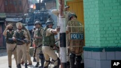 FILE - An Indian paramilitary soldier aims his sling at Kashmiri protesters near the site of a gunbattle in Srinagar, Indian-controlled Kashmir, May 5, 2018. 