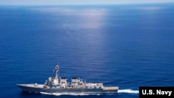 资料照：美国海军拉森号导弹驱逐舰在南中国海国际水域执行巡航任务，不远处就是中国海军的军舰。（2015年9月29日）