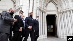 French President Emmanuel Macron, second right, Nice mayor Christian Estrosi, right, French Interior Minister Gerald Darmanin, second left, and Justice Minister Eric Dupond-Moretti arrive at Notre Dame church in Nice