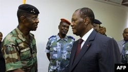 Ivory Coast's President Alassane Ouattara (R) shakes hands with General Philippe Mangou, chief of staff of former pro-Laurent Gbagbo Defense and Security Forces (FDS), at the Hotel du Golf in Abidjan, April 12, 2011.