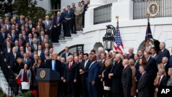 Президент США Дональд Трамп и вице-президент США Майк Пенс вместе с другими республиканцами празднуют принятие Конгессом США законопроекта о налоговой реформе. Южная лужайка Белого дома. Вашингтон. 20 декабря 2017 г.