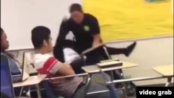FILE - An image from video shows Spring Valley High School (Columbia, S.C., student resource officer Ben Fields, a senior deputy with the Richland County police department, using force to remove a female student from a classroom, Oct. 26, 2015.