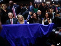 (Chapdan) Vitse-prezident Jo Bayden, uning rafiqasi Jil Bayden, birinchi xonim Mishel Obama va uning qizi Maliya Obama Prezident Barak Obamaning nutqini tinglamoqda, Chikago, 10-yanvar, 2017-yil.