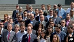 Venezuela's National Assembly President Julio Borges, center, surrounded by fellow legislators, speaks during a meeting with the media, in Caracas, Venezuela, April 18, 2017.