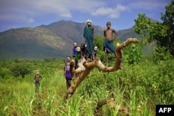 FILE - Children from the Suri tribe pose in Ethiopia's southern Omo Valley region, Sept. 25, 2016. The construction of a hydroelectric plant and factories along the Omo river are impacting heavily on the lives of tribes living in the Omo Valley who depend on the river for their survival and way of life.