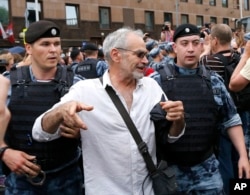 Police officers detain a supporter of Russian investigative journalist Ivan Golunov during a march in Moscow, June 12, 2019.
