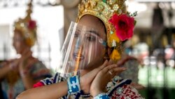 A Thai classical dancer wearing face shield to help curb the spread of the coronavirus performs at the Erawan Shrine in Bangkok, Thailand.