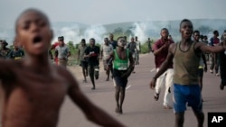 Supporters of opposition candidate Martin Fayulu run from tear gas fired by police in Nsele, 50kms east of Kinshasa, Democratic Republic of the Congo, Dec. 19, 2018.