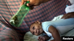 一位妈妈用绿色的瓶子刺激头小畸形4个月大的儿子（2016年2月11日）