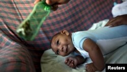 Jackeline, 26, uses a green bottle to stimulate to her son Daniel who is 4-months old and born with microcephaly, inside of their house in Olinda, near Recife, Brazil, Feb. 11, 2016. 