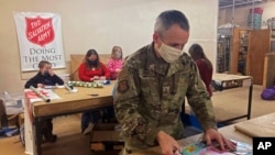 Chief Master Sgt. Winfield Hinkley Jr., Command Senior Enlisted Leader of the Alaska National Guard, wraps a gift in Anchorage, Alaska, that will be sent to a child in one of three rural Alaska villages, on Nov. 17, 2020.