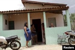 Adilma de Oliveira, 29, who is eight months pregnant, stands in front of her house in Congo, Brazil, Feb. 16, 2016.