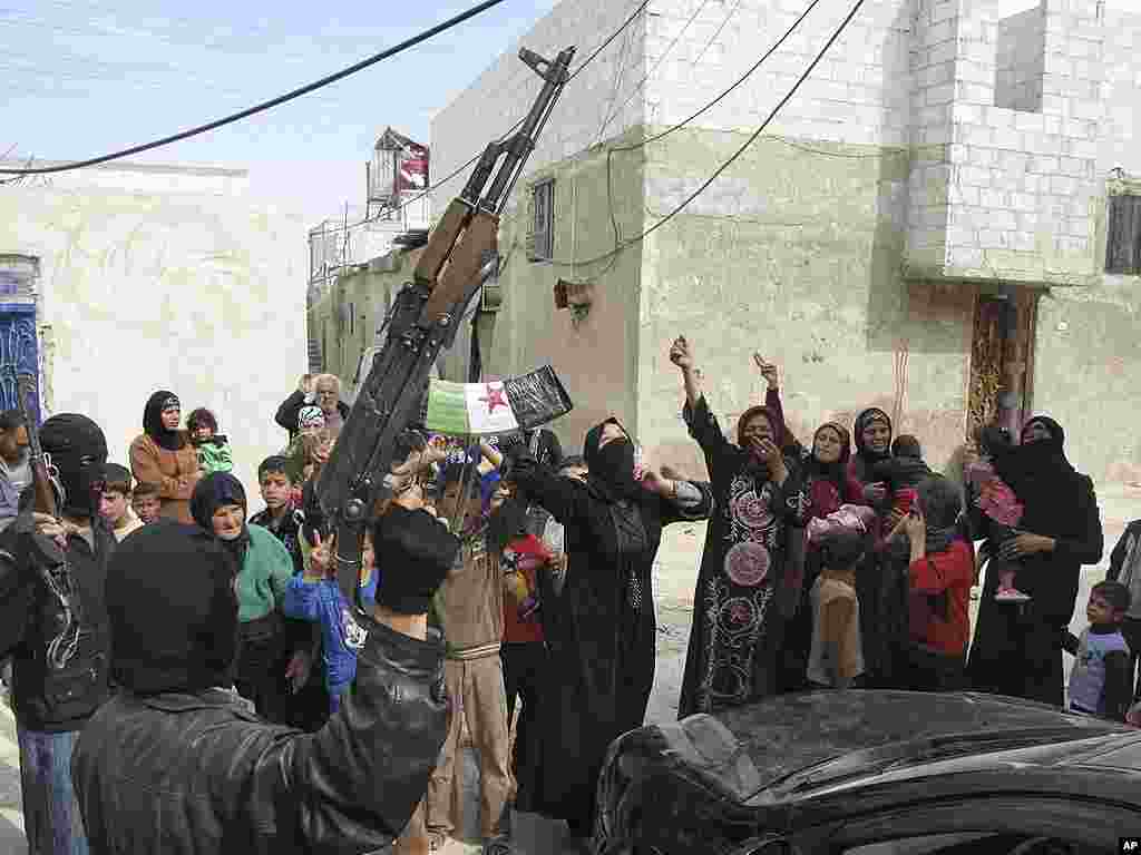 Syrians chant slogans against President Bashar Assad upon the arrival of the Free Syrian Army in a neighborhood in Damascus. (AP)