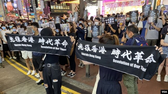 大批参与6-12一周年铜锣湾街头展览的市民手持反送中运动标语并高呼口号。 (美国之音特约记者 汤惠芸)