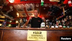 Johnny McFadden, 61, poses for a photo at the bar area of The Star Inn. An electric fence has been installed at the bar area to ensure customers are socially distanced in St Just, Cornwall, Britain July 14, 2020. (REUTERS/Tom Nicholson)