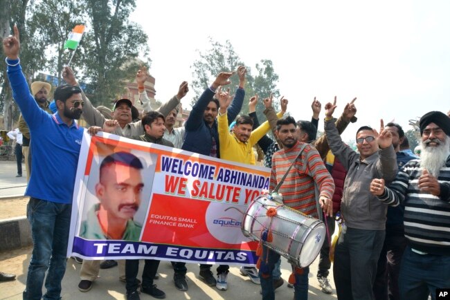 FILE - Indians dance as they wait to welcome Indian fighter pilot Wing Commander Abhinandan Varthaman at India Pakistan border at Wagah, 28 kilometers (17.5 miles) from Amritsar, India, March 1, 2019.