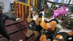 Rescuers carry a survivor out of the Qianqiu coal mine after a rock burst incident in Sanmenxia, Henan province, November 4, 2011