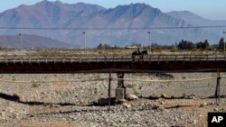 En esta foto del 23 de septiembre de 2019, un jinete cruza un puente sobre el lecho de un río que quedó seco por la peor sequía de Chile en más de medio siglo, en Putaendo. 