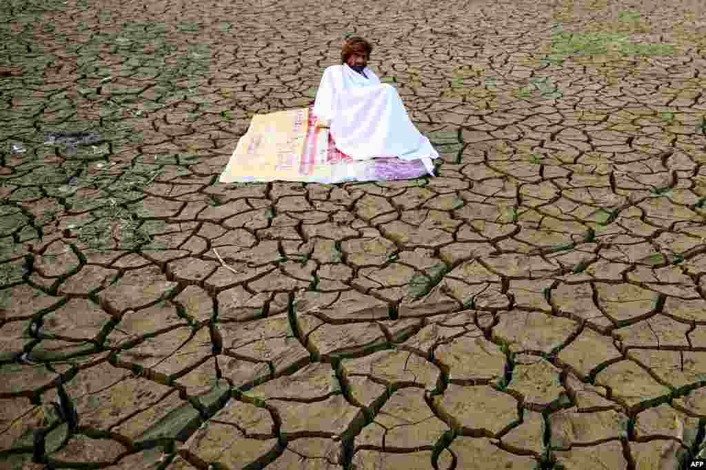 Seorang pria duduk di tepi Sangam - daerah di sekitar pertemuan sungai Gangga, Yamuna, dan Saraswati yang dianggap suci (keramat) - setelah air surut di kota Allahabad, India.