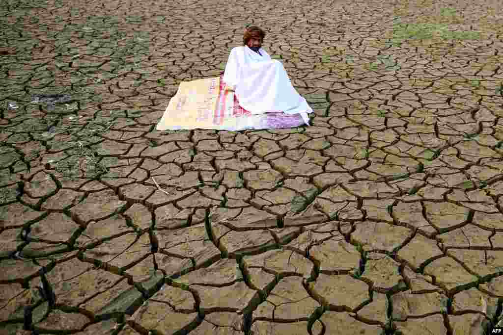 A man sits on the banks of Sangam -- the area around the meeting point of rivers Ganges, Yamuna, and mythical Saraswati -- after floodwaters receded in Allahabad, India.