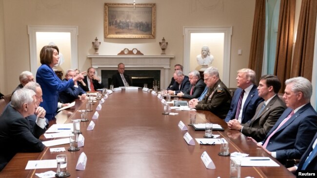 资料照片：众议院议长佩洛西在白宫举行的一次有关叙利亚问题的会议上站起身来对着特朗普总统讲话。(2019年10月16日)