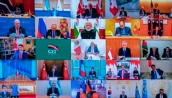 This photo of a television screen taken and handout by the press office of Palazzo Chigi on March 26, 2020 shows Italian Prime Minister, Giuseppe Conte (Bottom L) taking part in a video conference as part of an extraordinary meeting of G20 leaders