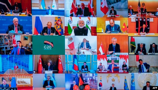 This photo of a television screen taken and handout by the press office of Palazzo Chigi on March 26, 2020 shows Italian Prime Minister, Giuseppe Conte (Bottom L) taking part in a video conference as part of an extraordinary meeting of G20 leaders