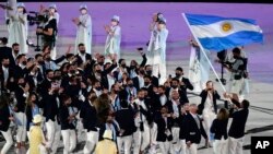Cecilia Carranza Saroli and Santiago Raul Lange, of Argentina, right, carry their country's flag during the opening ceremony in the Olympic Stadium at the 2020 Summer Olympics, Friday, July 23, 2021, in Tokyo, Japan. (AP Photo/Patrick Semansky)