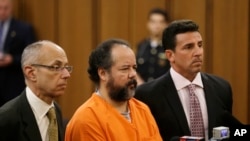 Ariel Castro, center, stands with defense attorneys during arraignment on 977-count indictment, Cleveland, July 17, 2013.