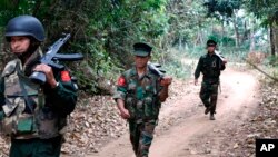 Kachin Independence Army fighters walk in a jungle path from Mu Du front line to Hpalap outpost in an area controlled by the Kachin rebels in northern Kachin state, Myanmar, March 17, 2018.