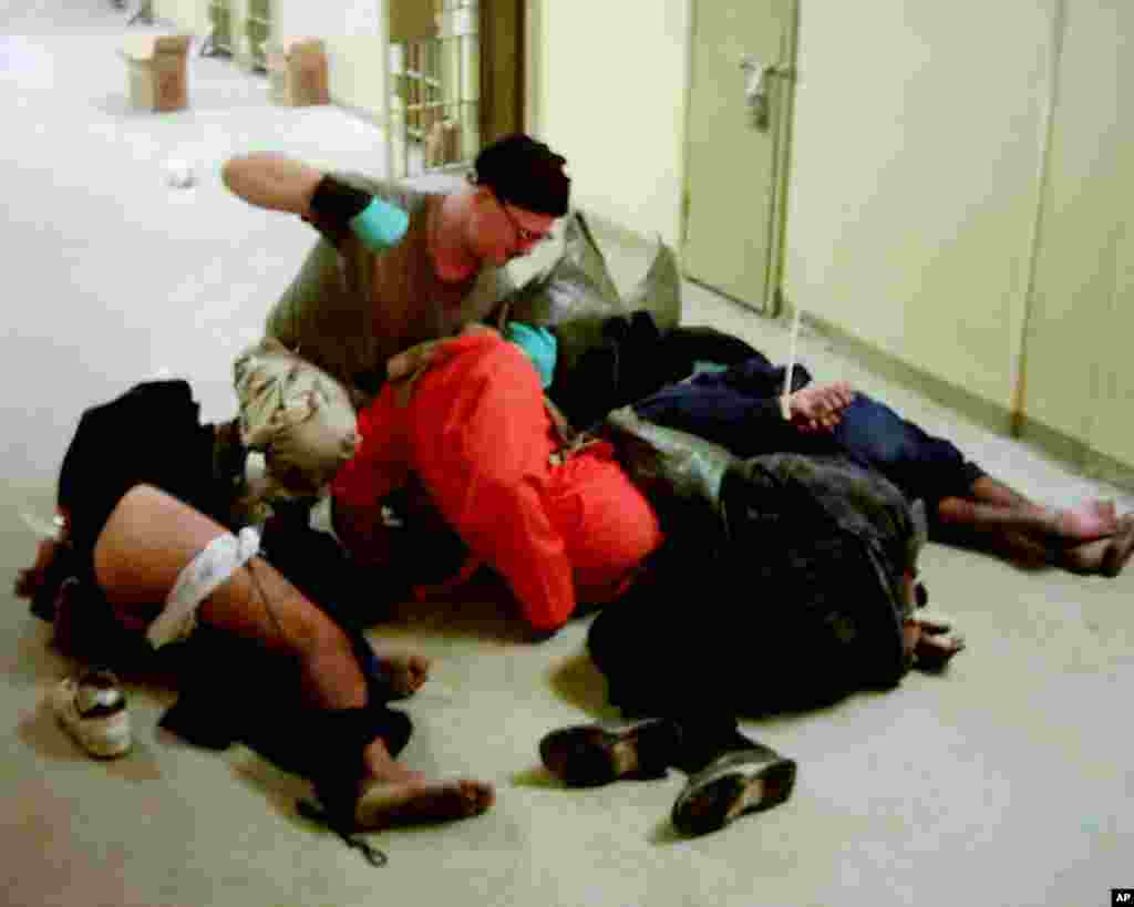 This image obtained by The Associated Press shows Cpl. Charles A. Graner Jr. appearing to punch one of several handcuffed detainees lying on the floor in late 2003 at the Abu Ghraib prison in Baghdad, Iraq.