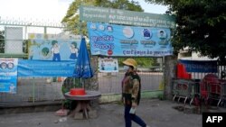 រូបឯកសារ៖ ស្ត្រីម្នាក់ពាក់ម៉ាស់ដើរកាត់សាលារៀនមួយដែលបានបិទទ្វារ ខណៈមានការបារម្ភពីការឆ្លងរាតត្បាតនៃជំងឺកូវីដ ១៩ នៅទីក្រុងភ្នំពេញ ថ្ងៃទី១២ ខែវិច្ឆិកា ឆ្នាំ២០២០។