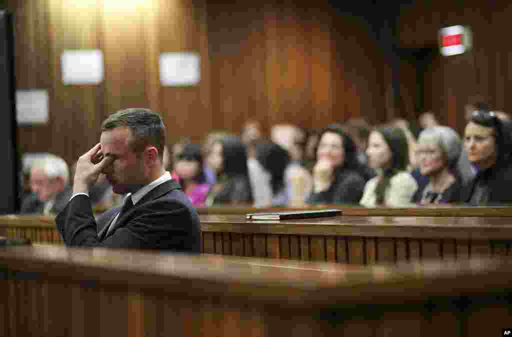 Oscar Pistorius rubs his eye in court in Pretoria, South Africa after earlier questioning by state prosecutor Gerrie Nel. Pistorius is charged with the murder of his girlfriend Reeva Steenkamp.